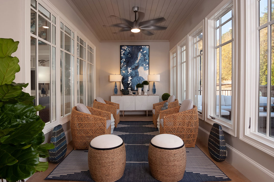 Indoor patio with rattan furniture and blue patterned rug