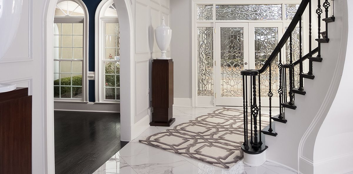 White and black staircase of a house with white doors and white marble flooring