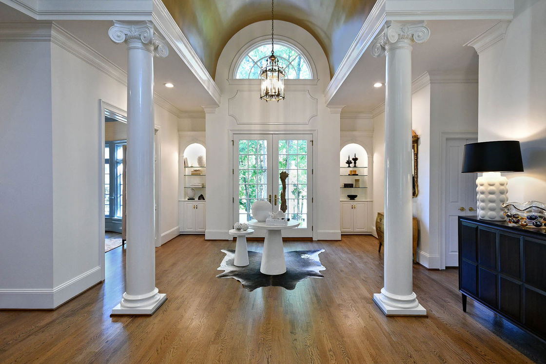 Tall white columns placed on an indoor entryway of a house