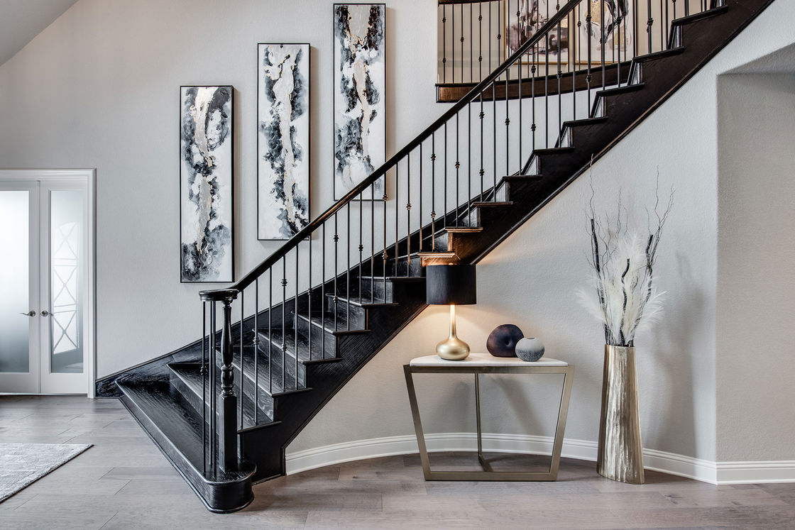 White house with black painted staircase and matching art displays