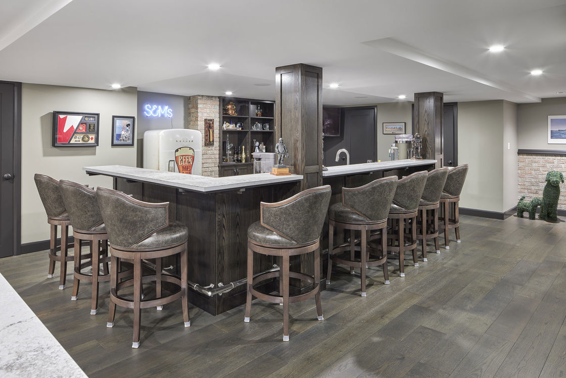 Home bar with leather upholstered stools with white granite countertop
