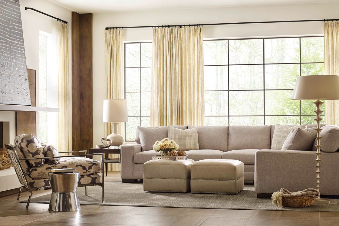 Classic living room with long gray sofa and tall windows and drapery