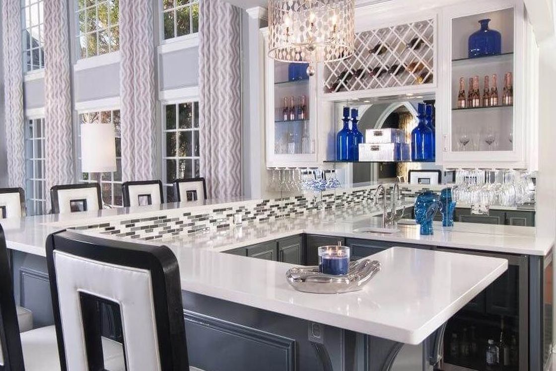 Posh kitchen with stylish countertop and black and white chairs