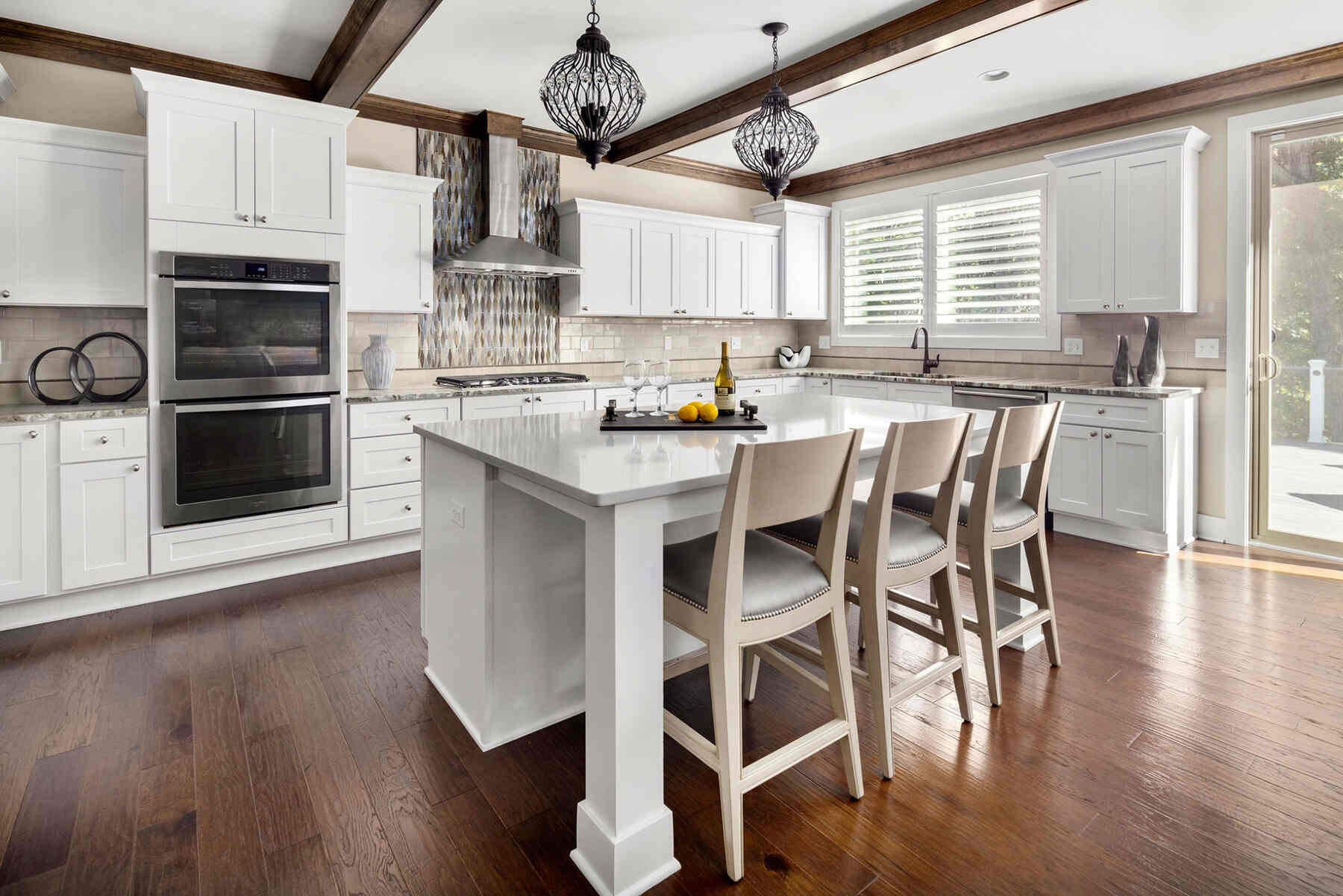 Kitchen with white table and and white cabinets and wooden flooring