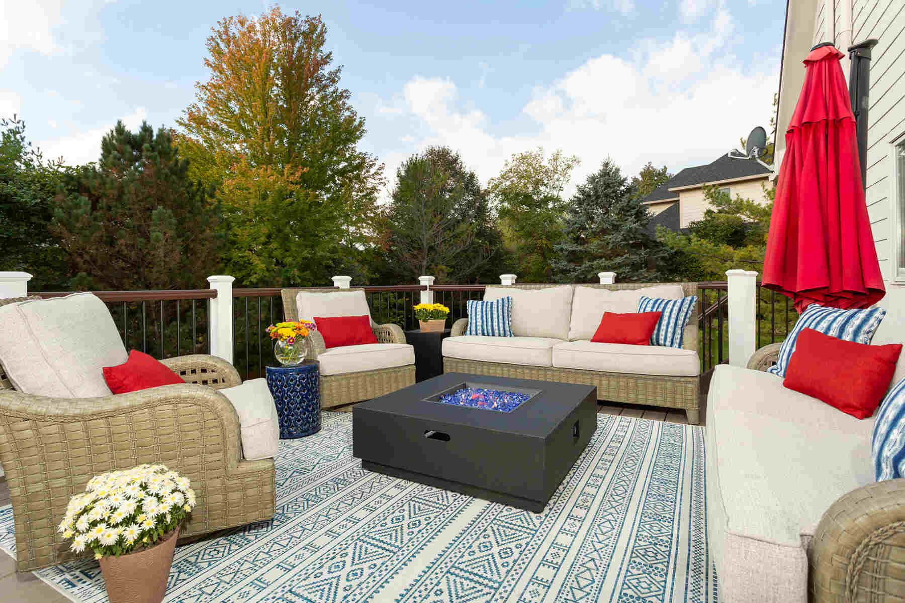 Outdoor patio with blue printed rug and matching weaved furniture