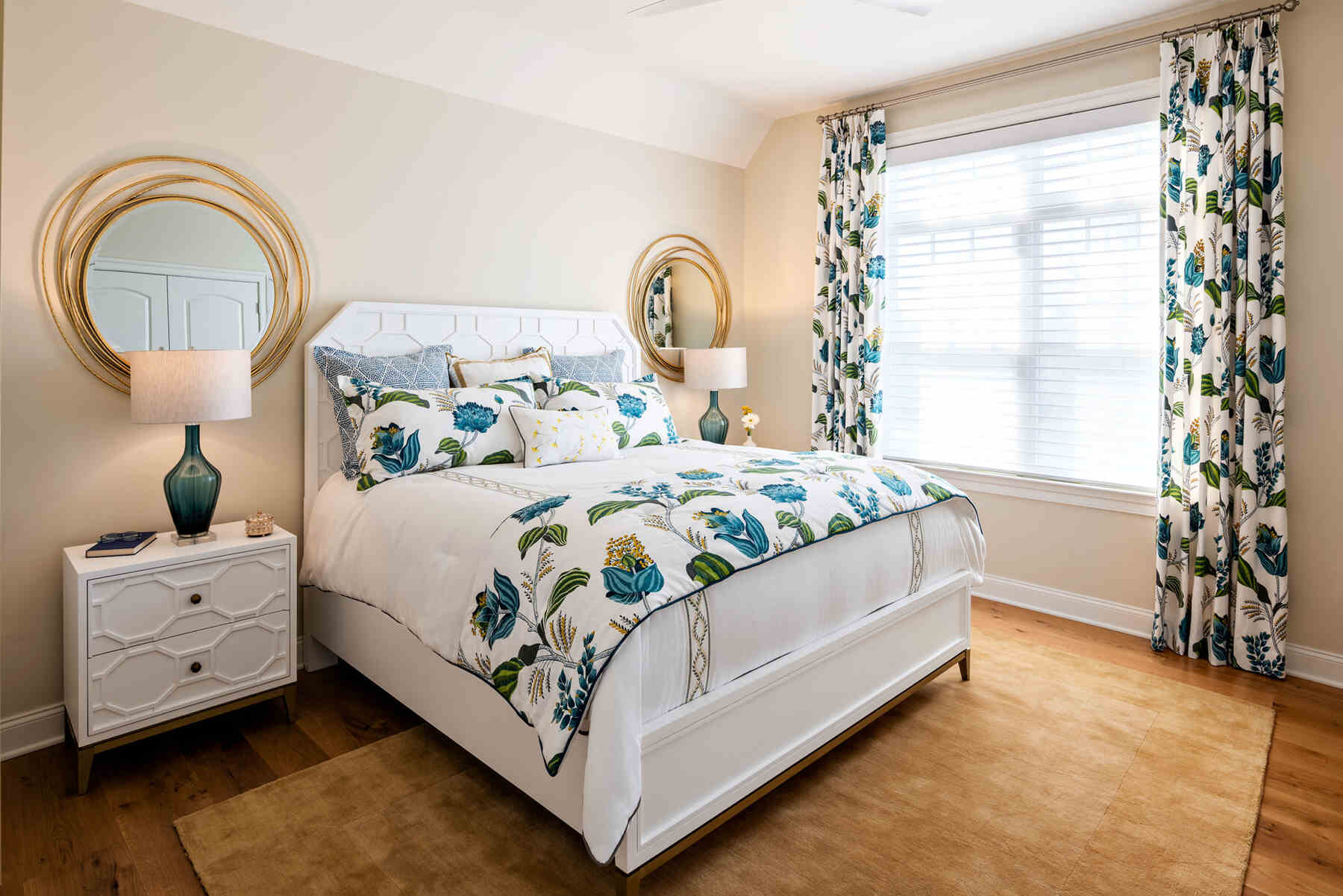Bedroom with blue floral accents, matching side tables, lamps and mirrors