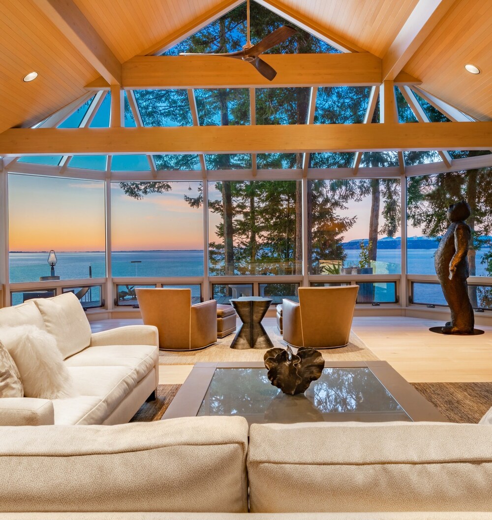 A living room with high ceiling and a nice outdoor view of coastal