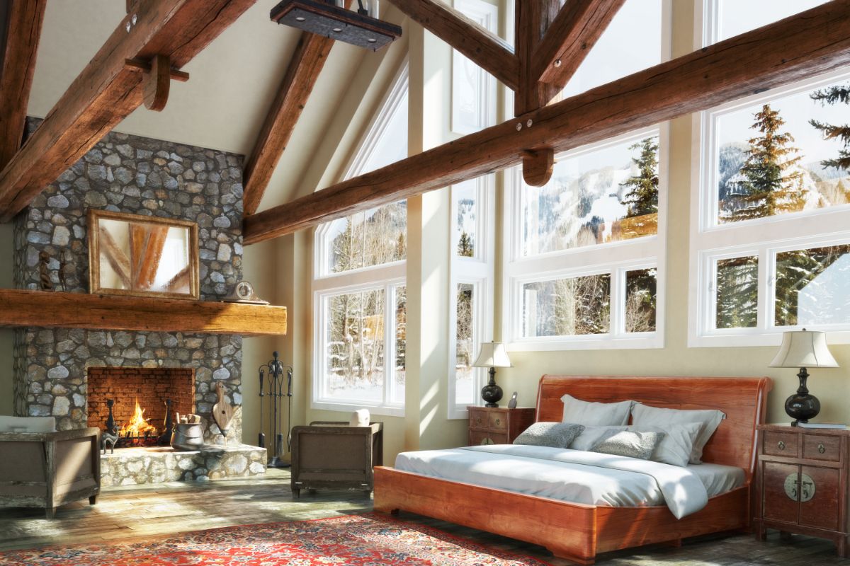 Bedroom with a stone fireplace and high ceilings